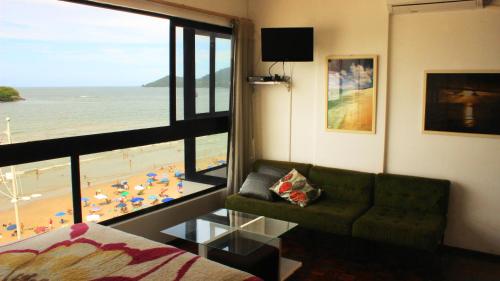 sala de estar con sofá y vistas a la playa en Totalmente de Frente ao Mar, en Balneário Camboriú