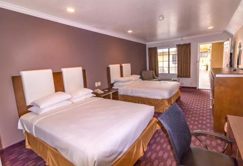 una camera d'albergo con 2 letti e una scrivania di Hotel Pacific, Manhattan Beach a Manhattan Beach