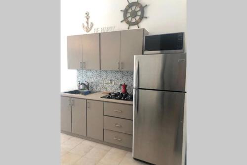 a kitchen with a stainless steel refrigerator and cabinets at CARMELORIA III in Rincon