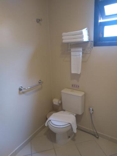 a bathroom with a toilet and towels on the wall at Hotel Costa Balena-Piscina Aquecida Coberta in Guarujá