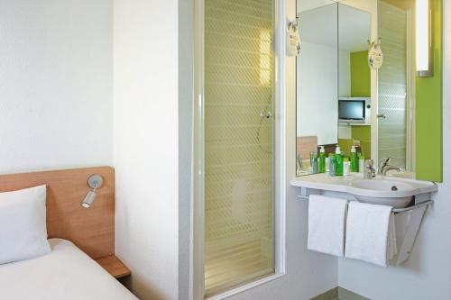 uma casa de banho com um lavatório e um espelho em ibis budget Katowice Centrum em Katowice