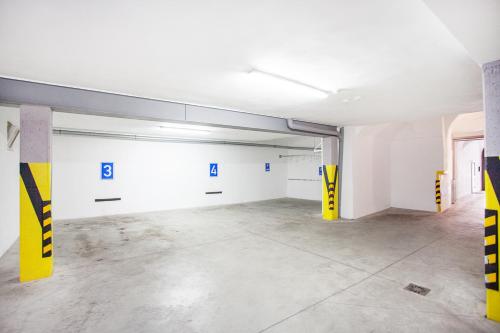 an empty garage with yellow and white walls at Hotel U Tří hrušek suites & apartments in České Budějovice