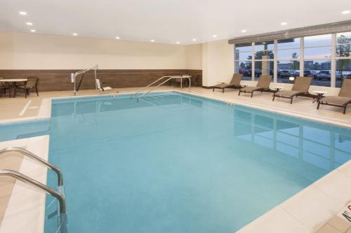 a large swimming pool with chairs and a table at Holiday Inn Express & Suites Sandusky by IHG in Sandusky