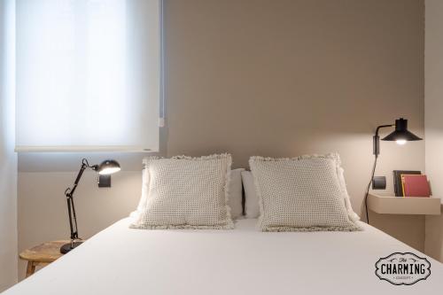 une chambre avec un lit blanc avec deux oreillers dans l'établissement Retiro Chic - Apartamento de 1 dormitorio, à Madrid