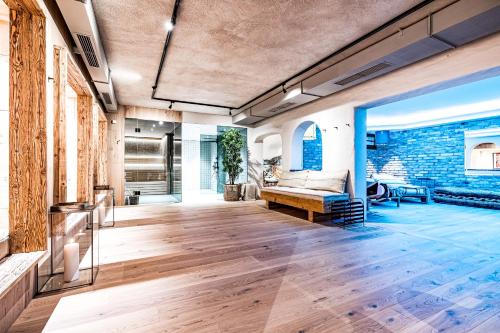 a living room with a couch and a brick wall at Hotel LÜ - Adults Only in Obertauern