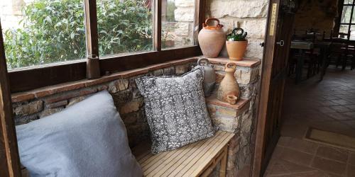 a bench with pillows and vases on a stone wall at Mas de l'Arlequi in Rojals