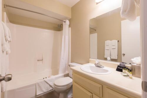 a bathroom with a sink and a toilet and a mirror at Indian Palms Vacation Club in Indio