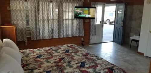 a bedroom with a bed and a flat screen tv at Nautical Motel in Hampton