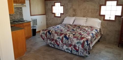 a bedroom with a bed and a kitchen with windows at Nautical Motel in Hampton