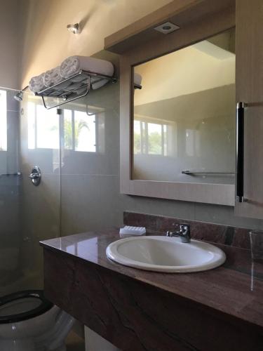 a bathroom with a sink and a toilet and a mirror at Brisas de San Lorenzo Posada Lounge in Porlamar