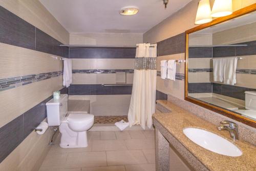 bagno con servizi igienici, lavandino e specchio di Hotel Pacific, Manhattan Beach a Manhattan Beach