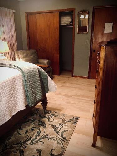 a bedroom with a bed and a chair and a rug at WINNIE'S BED & BREAKFAST in Lawrenceburg