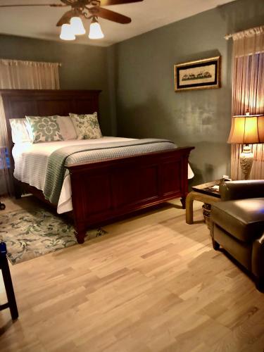 a bedroom with a bed and a chair and a couch at WINNIE'S BED & BREAKFAST in Lawrenceburg