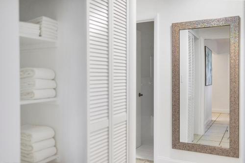 uma casa de banho com um espelho e paredes brancas em Alani Bay Premium Condos em Fort Lauderdale