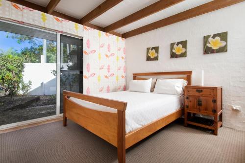 a bedroom with a bed and a large window at Waterfront on Witta Circle in Noosa Heads