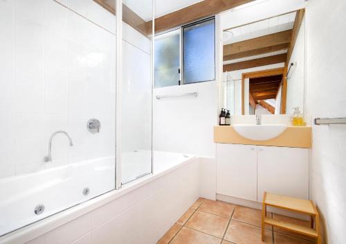 a bathroom with a tub and a sink and a shower at Waterfront on Witta Circle in Noosa Heads