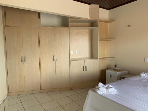 a bedroom with wooden cabinets and a bed at Pousada Litorânea in São Luís