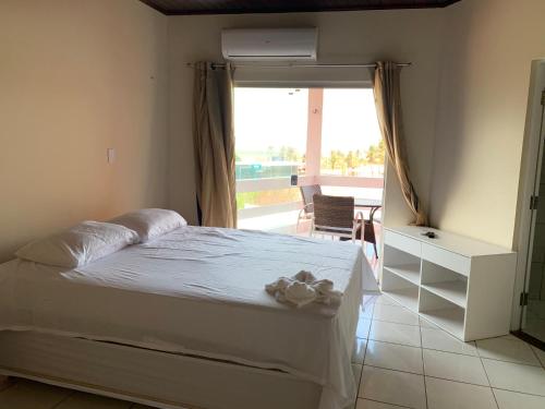a bedroom with a bed and a large window at Pousada Litorânea in São Luís