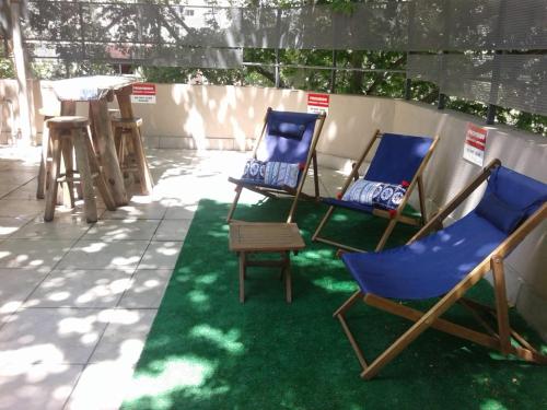 2 sillas azules y una mesa en el patio en Ubicadisimo dto. Loft con terraza privada en Mendoza