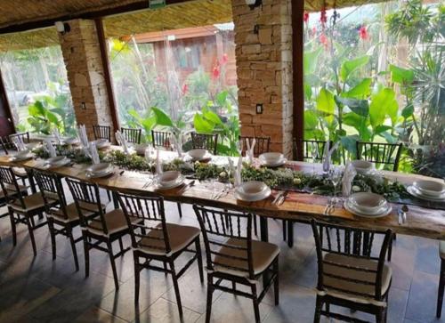 une grande table dans une pièce avec des chaises et une grande fenêtre dans l'établissement Cabañas la finca 2, à Atlixco