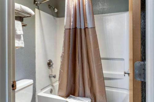 a bathroom with a shower curtain next to a tub at Econo Lodge West - Coors Blvd in Albuquerque