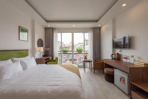 a hotel room with a large bed and a desk at AMI Old Quarter Hotel in Hanoi