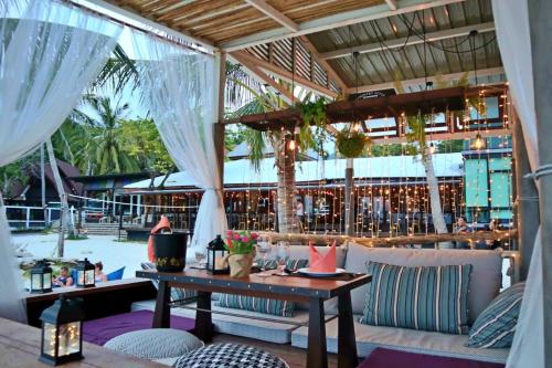 d'une terrasse avec une table, des chaises et un bar. dans l'établissement Cocohut Beach Resort & Spa, à Haad Rin