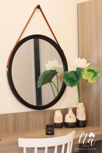 a mirror sitting on top of a table with vases at Na Homestay in Hue