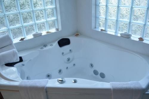 a white bath tub sitting next to a window at Lisson Grove in Mount Tamborine