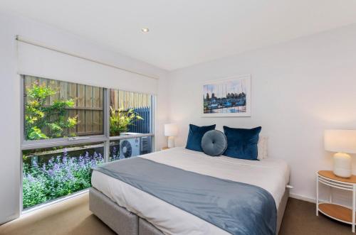a bedroom with a bed and a large window at The Victoria Apartments in Port Fairy