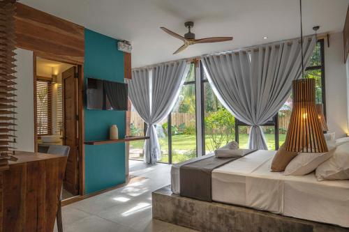a bedroom with a bed and a large window at Bird of Paradise in Panglao