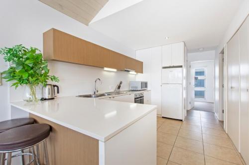 a white kitchen with a sink and a counter at The Victoria Apartments in Port Fairy