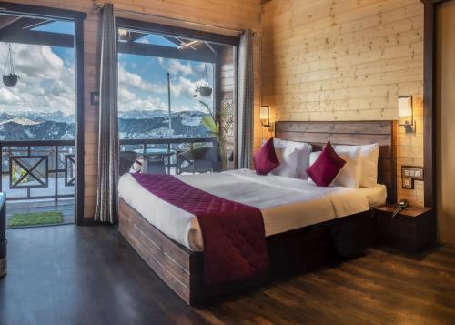 Woodays Resort في شيملا: غرفة نوم بسرير كبير ونافذة كبيرة