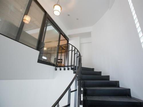 a staircase in a house with a glass wall at THE HOTELS HAKATA KASANE Bayside in Fukuoka