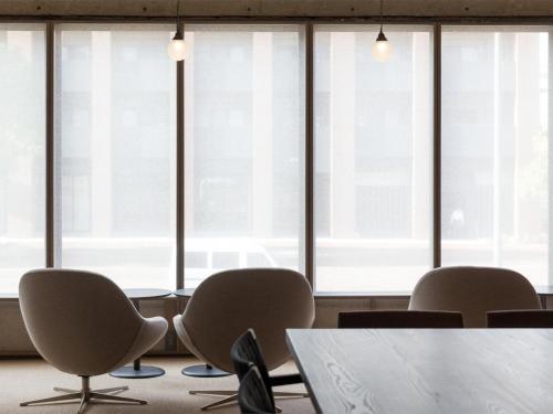 a conference room with chairs and a table and windows at THE HOTELS HAKATA KASANE Bayside in Fukuoka