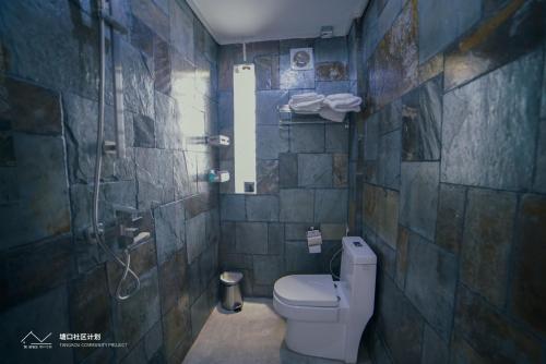 a bathroom with a toilet and a shower at Kaiping Tangkou Village Inn in Jiangmen