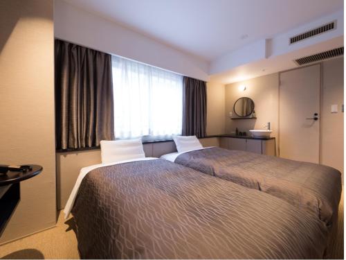 a hotel room with two beds and a window at THE HOTELS HAKATA KASANE Bayside in Fukuoka