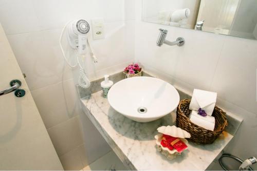 a white bathroom with a sink and a mirror at Canto das Laranjeiras Villa in Guarujá