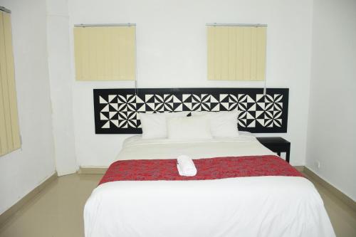 a bedroom with a large white bed with a red blanket at Best View Apartments in Nadi