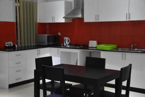 a kitchen with a black table and chairs in it at Best View Apartments in Nadi