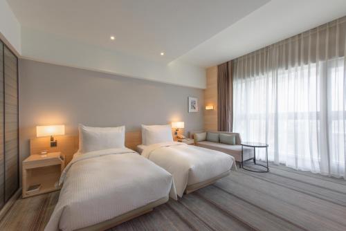 Postel nebo postele na pokoji v ubytování Hotel COZZI Ximen Tainan