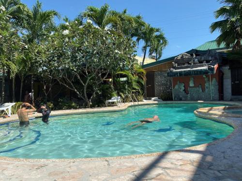 a group of people swimming in a swimming pool at Marina Village in Moalboal