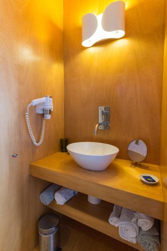 a bathroom with a white bowl sink on a wooden counter at Baía das Caldeirinhas in Horta