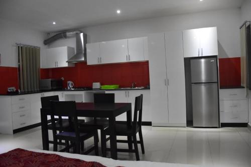 a kitchen with a table and chairs and a refrigerator at Best View Apartments in Nadi