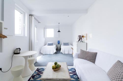 a white living room with a white couch and a table at Baía das Caldeirinhas in Horta