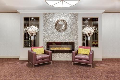 a living room with two chairs and a fireplace at Holiday Inn Toronto International Airport by IHG in Toronto