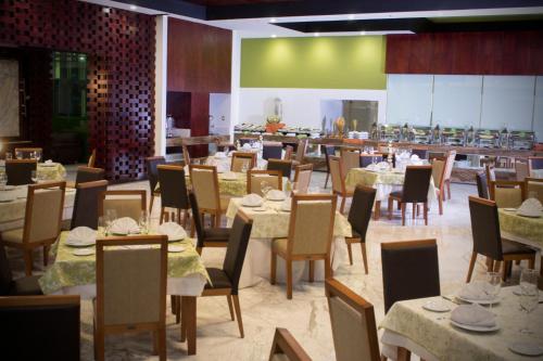 a dining room with tables and chairs and a cafeteria at Holiday Inn Queretaro Zona Krystal by IHG in Querétaro