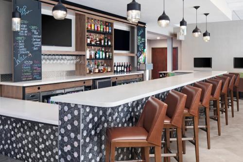 a bar with a row of chairs and a long counter at Holiday Inn Odessa by IHG in Odessa