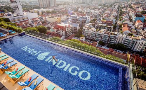 a swimming pool on top of a building with a city at Hotel Indigo Singapore Katong, an IHG Hotel in Singapore