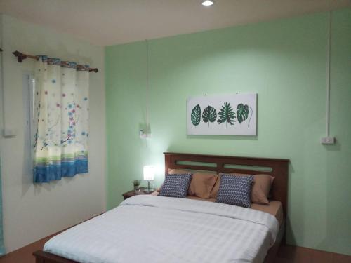 - une chambre avec un grand lit et des oreillers bleus dans l'établissement บ้านสวนคุณตา Baan Suan Khun ta, à Ko Chang